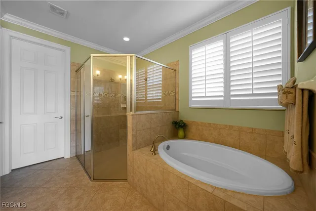 a bedroom with a bed and a potted plant on the dresser