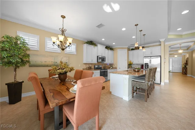 a view of a dining room and livingroom with furniture wooden floor a chandelier