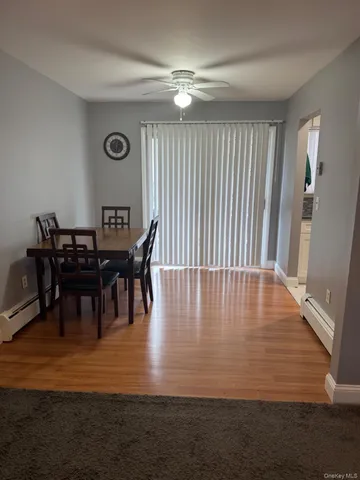 a view of dining room and livingroom with furniture wooden floor a rug and a chandelier
