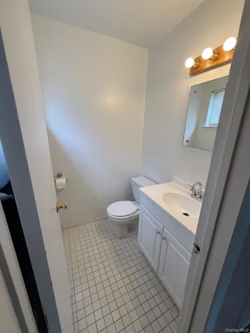 a bathroom with a sink a toilet a light fixture and a mirror