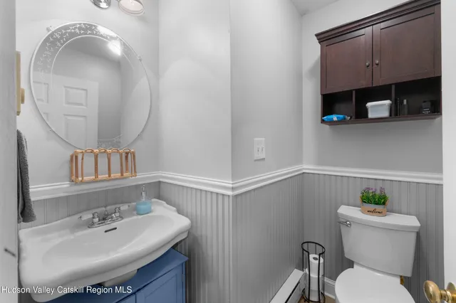 a bathroom with a sink a toilet and a mirror