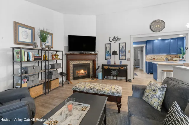 a living room with furniture a flat screen tv and a fireplace
