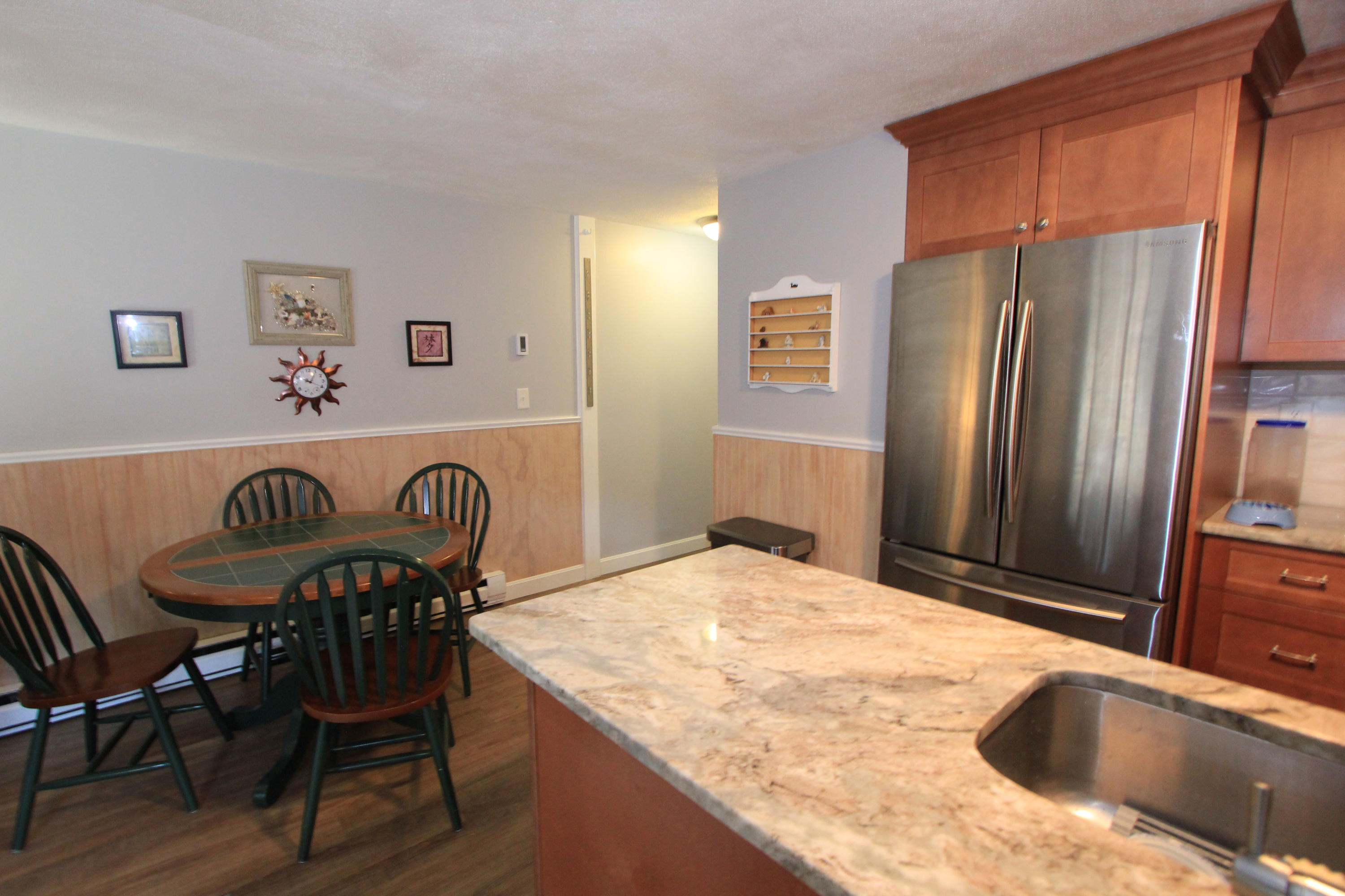 35 Ashumet Road, Unit 10B Mashpee, MA 02649 - Photo 7 of 13 a kitchen with a table chairs refrigerator and microwave