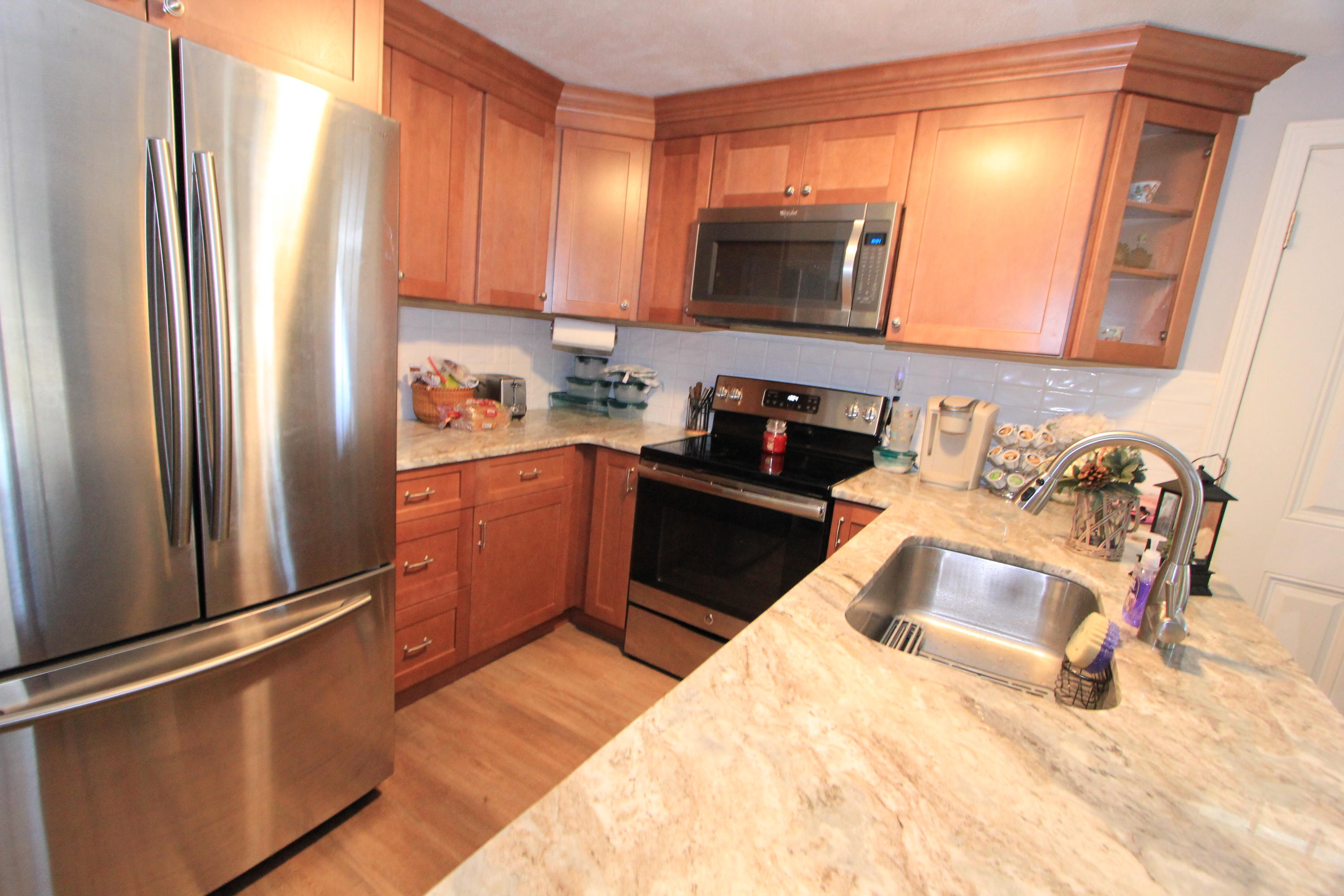 35 Ashumet Road, Unit 10B Mashpee, MA 02649 - Photo 9 of 13 a kitchen with granite countertop a refrigerator stove and sink
