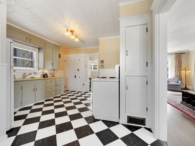 a kitchen with a checkered floor and white cabinets