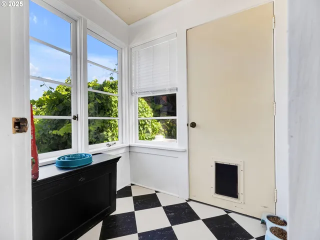 a room with a black white checkered floor with a gaming machine and a potted plant