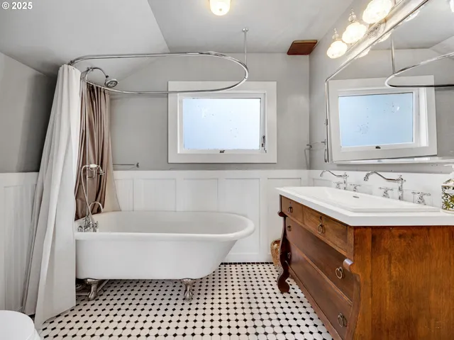 a bathroom with a sink a bathtub a mirror a vanity and a shower