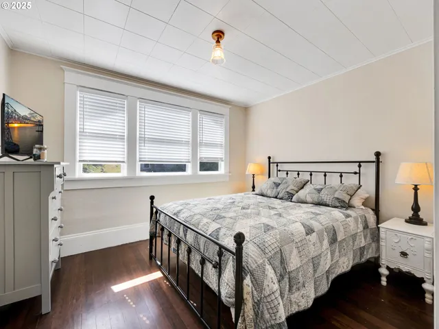 a bedroom with a bed and a flat tv screen on the dresser