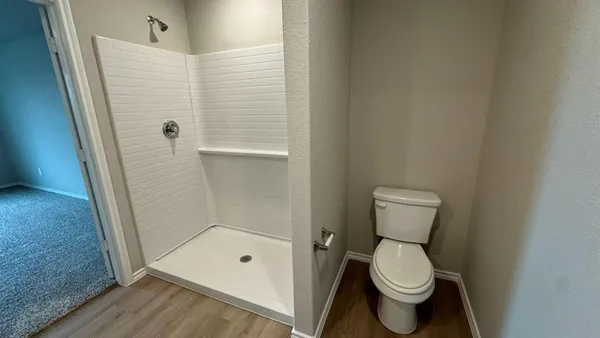 a bathroom with a toilet and a shower