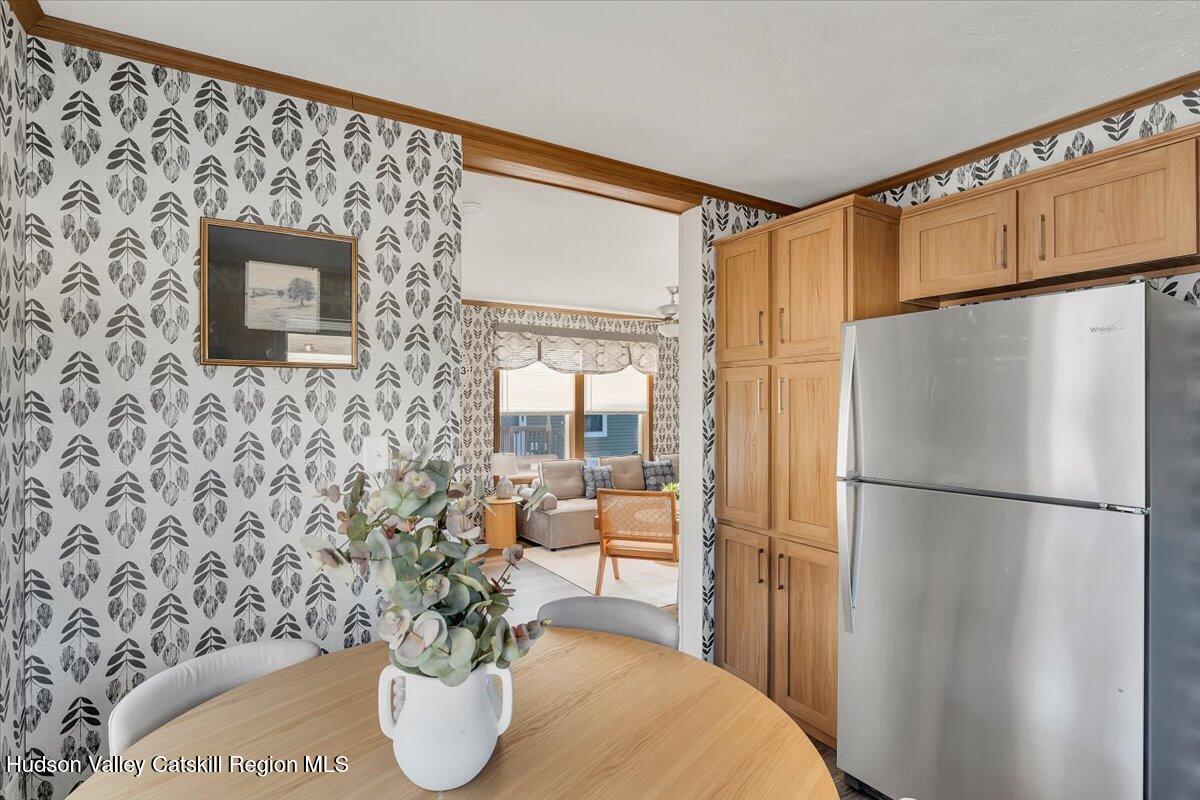 185 Old State Road, Unit 55 Broadalbin, NY 12025 - Photo 13 of 62 a kitchen with a refrigerator and a table chair