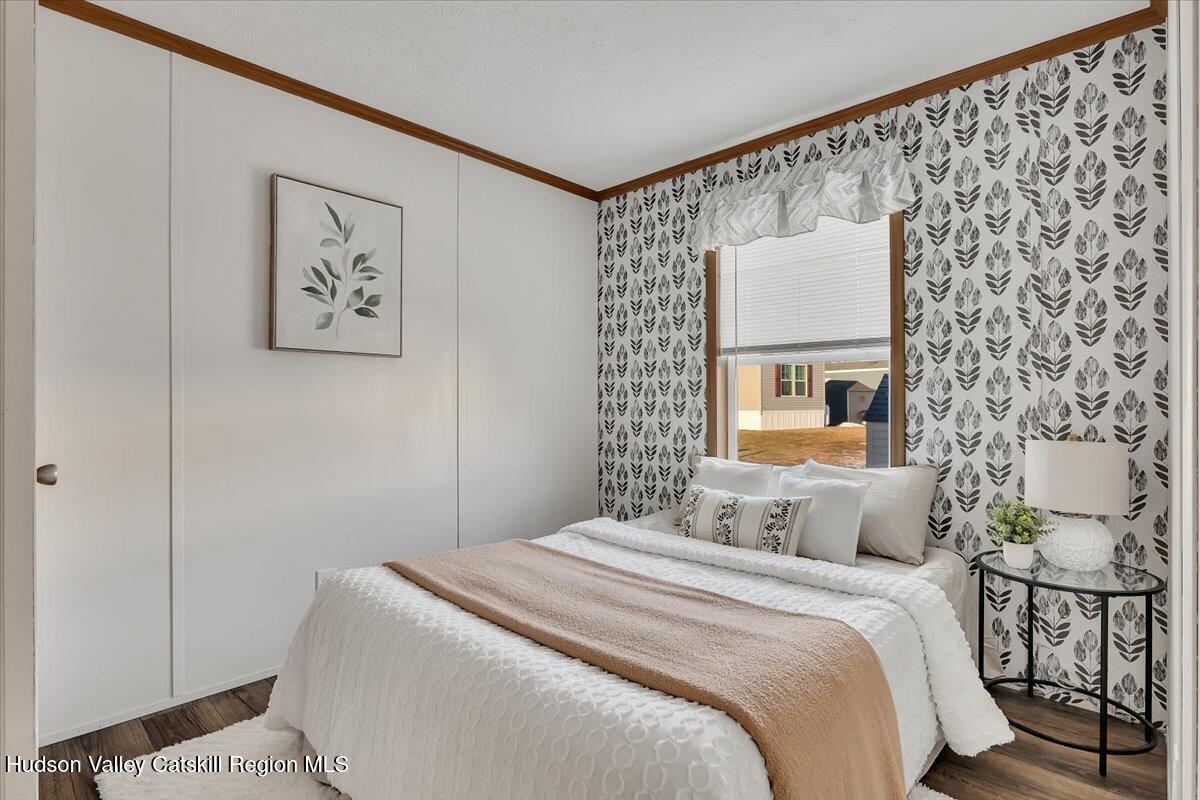 185 Old State Road, Unit 55 Broadalbin, NY 12025 - Photo 16 of 62 a bedroom with a bed and a wall painting