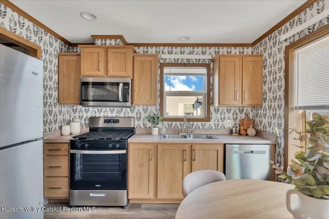 a kitchen with stainless steel appliances a stove a sink and a microwave