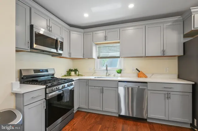a kitchen with stainless steel appliances granite countertop a sink and a stove
