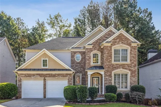 a front view of a house with a yard and garage
