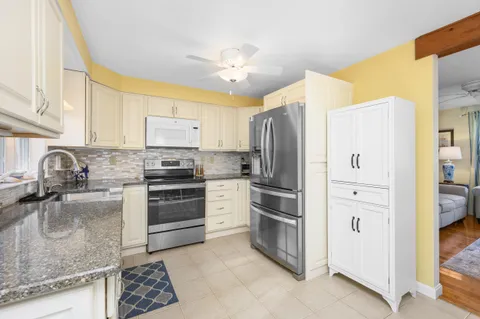 a kitchen with stainless steel appliances granite countertop a refrigerator sink and stove