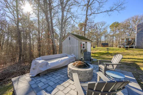 a backyard of a house with barbeque oven table and chairs