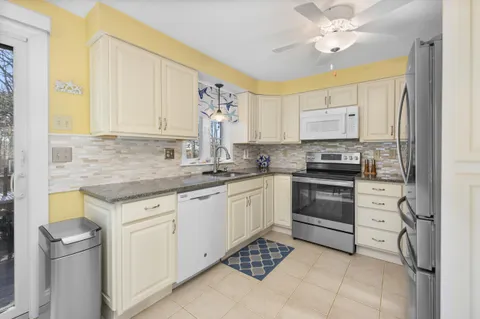 a kitchen with stainless steel appliances granite countertop a sink a stove and cabinets