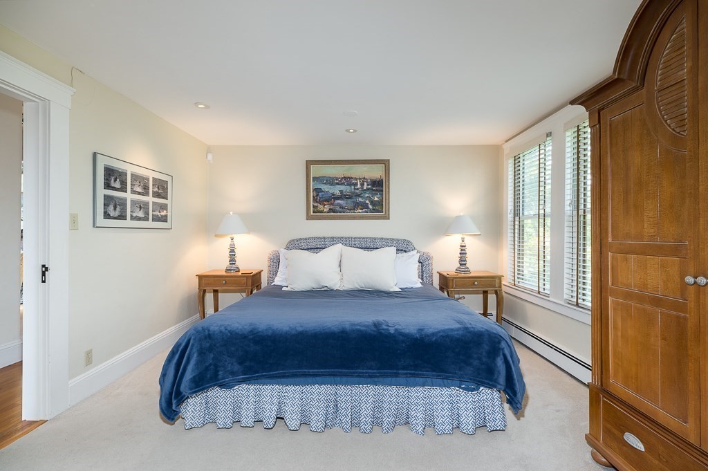 15 Cliff Road Gloucester, MA 01930 - Photo 15 of 42 a bedroom with a bed a painting and a lamp