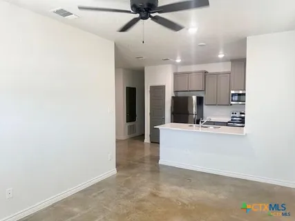 a view of kitchen with refrigerator stove microwave and cabinets