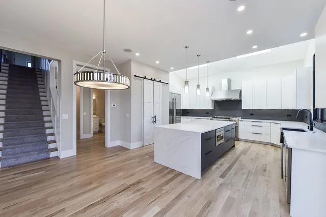 a large kitchen with stainless steel appliances granite countertop a lot of counter space and wooden floors