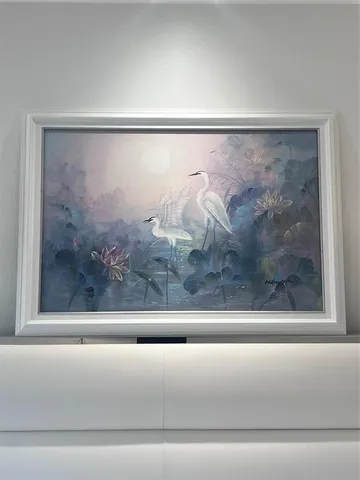 a bathroom with a toilet and a painting on the wall