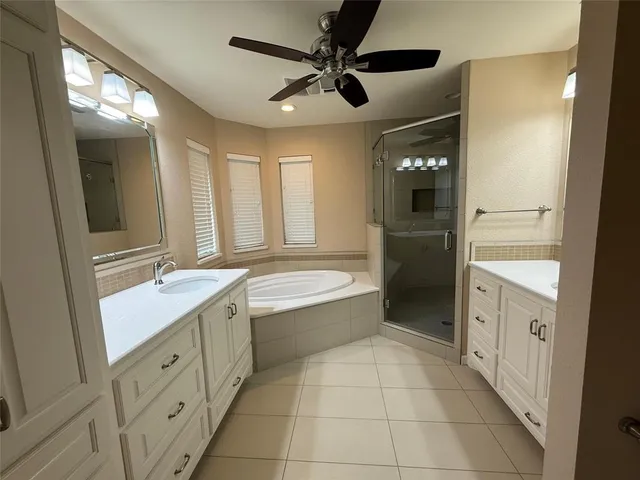 a bathroom with a granite countertop sink a mirror and a bathtub