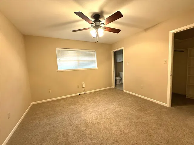 an empty room with closet and ceiling fan