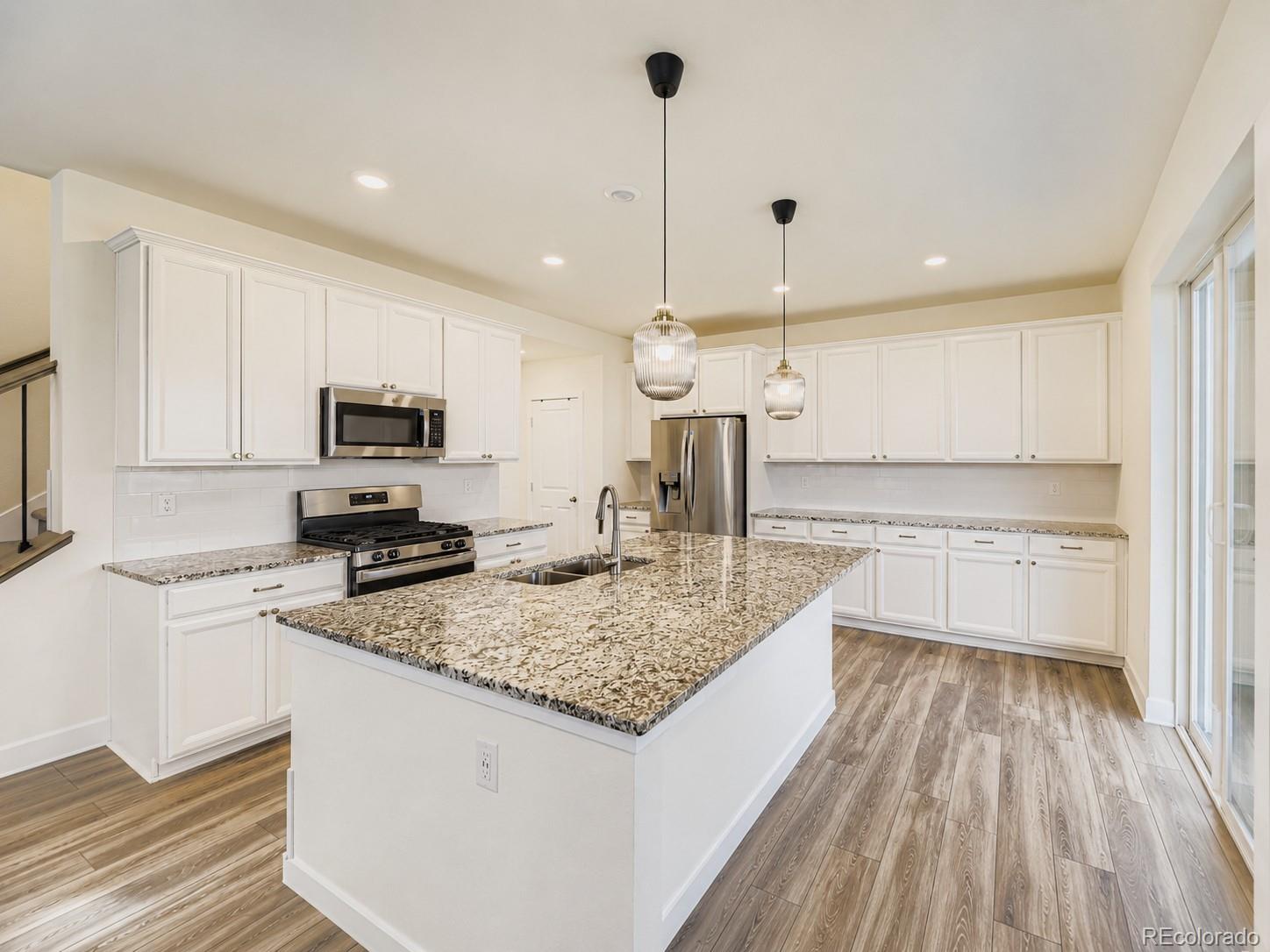 1173 Williams Loop Elizabeth, CO 80107 - Photo 8 of 30 a kitchen with kitchen island granite countertop a sink appliances and cabinets