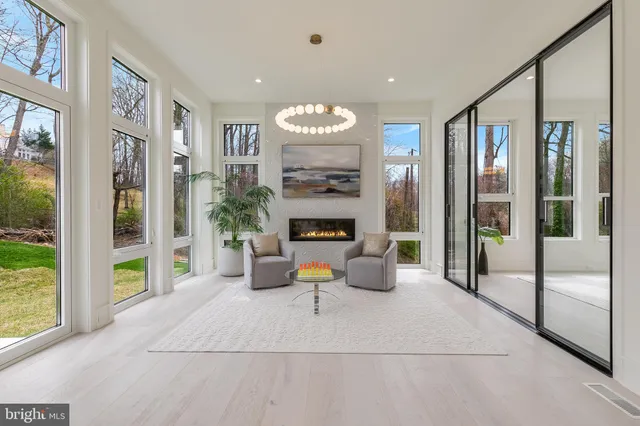 a living room with furniture a fireplace and a large window