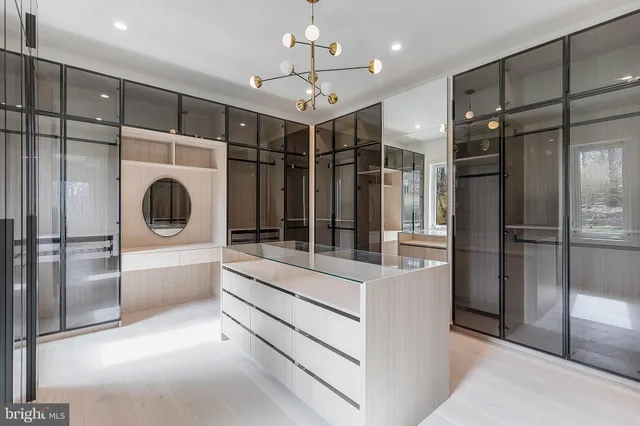 a large white kitchen with a large window and stainless steel appliances