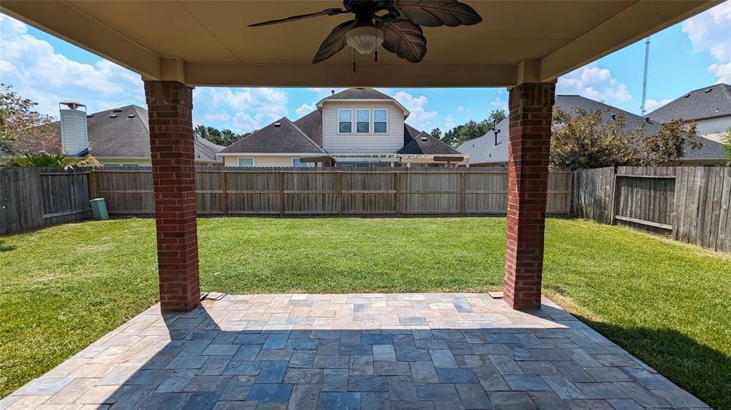 20909 Springport Court Katy, TX 77450 - Photo 31 of 39 Charming covered patio with ceiling fan overlooking a spacious, fenced backyard, perfect for relaxation and outdoor entertaining.