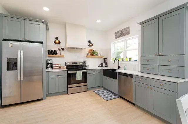 a kitchen with a sink stainless steel appliances and window