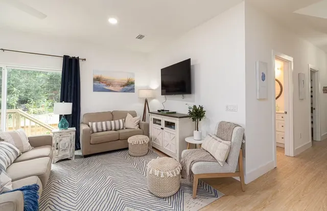 a living room with furniture a flat screen tv and a large window
