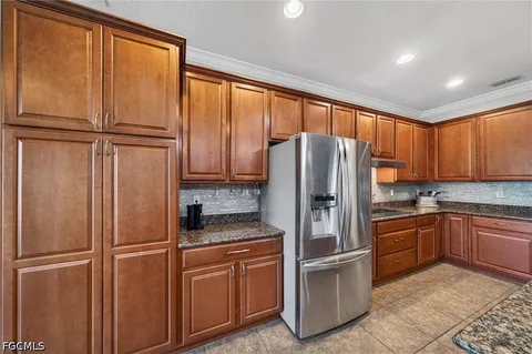 a kitchen with stainless steel appliances granite countertop a refrigerator and a sink