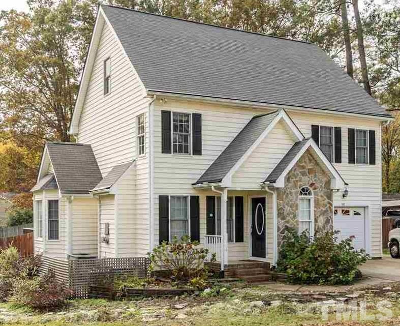 501 Woodland Road Raleigh, NC 27603 - Photo 1 of 28 a view of a white house with a yard and potted plants