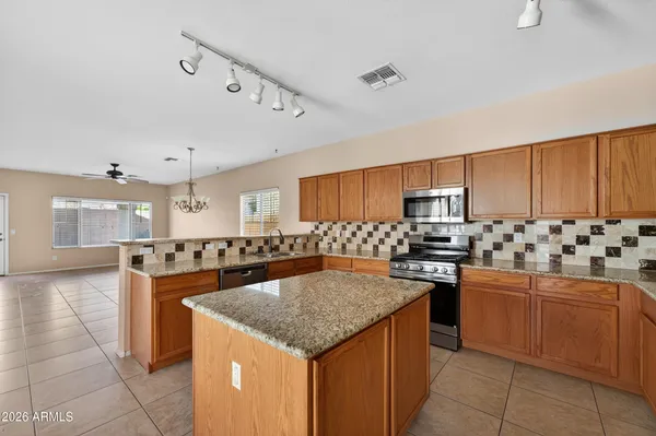 a kitchen with a stove a sink a refrigerator and red cabinets