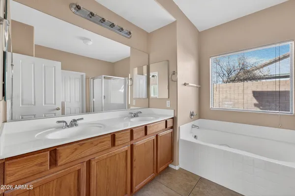 a bathroom with a tub a sink and a mirror