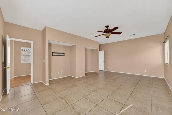 an empty room with closet and a ceiling fan