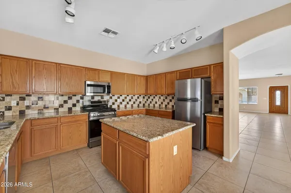 a kitchen with stainless steel appliances granite countertop a refrigerator and a stove