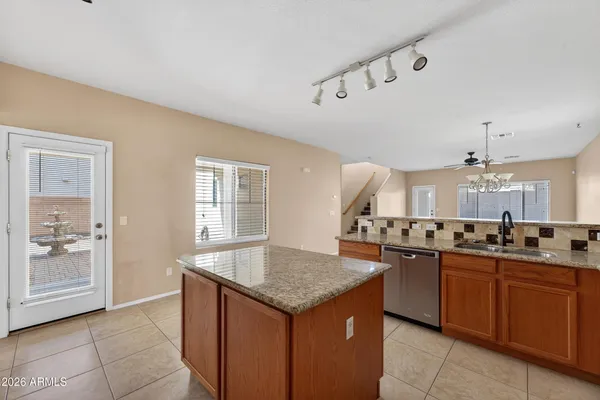 a kitchen with granite countertop stove sink and cabinets