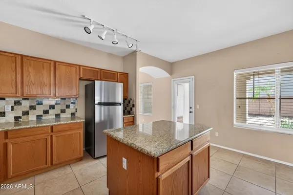 a kitchen with stainless steel appliances granite countertop a refrigerator a stove and a sink with wooden floor