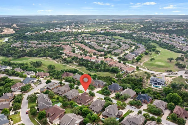 an aerial view of residential houses with outdoor space and trees