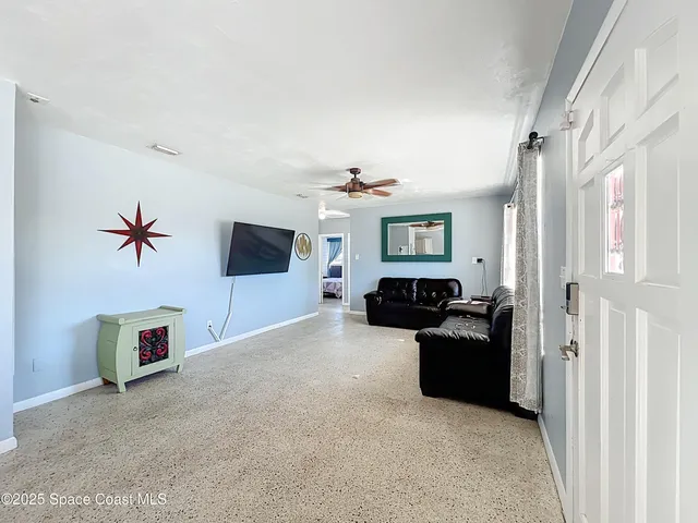 a living room with stainless steel appliances kitchen island granite countertop furniture and a sink
