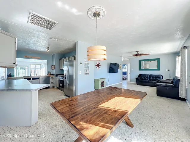 a large kitchen with a large window and stainless steel appliances