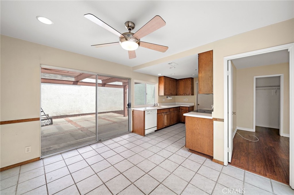 14272 Raintree Road Tustin, CA 92780 - Photo 6 of 24 a open kitchen with kitchen island granite countertop a refrigerator a sink and dishwasher