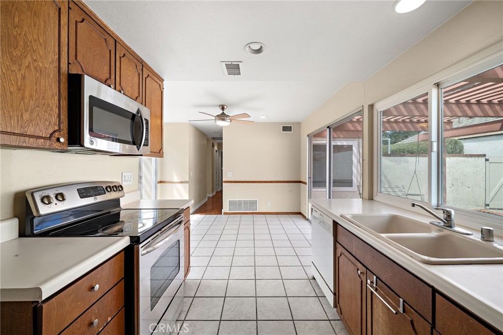 14272 Raintree Road Tustin, CA 92780 - Photo 9 of 24 a kitchen with a sink a stove and cabinets