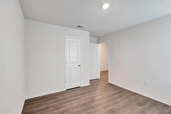 a view of an empty room and wooden floor