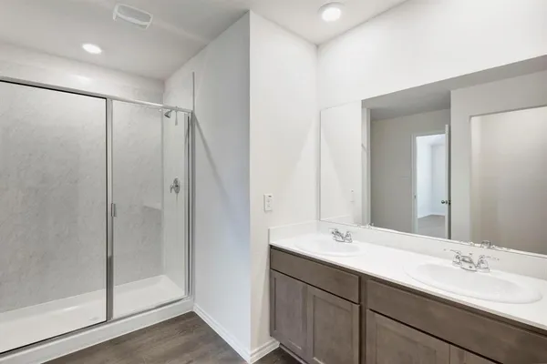 a bathroom with a double vanity sink mirror and shower