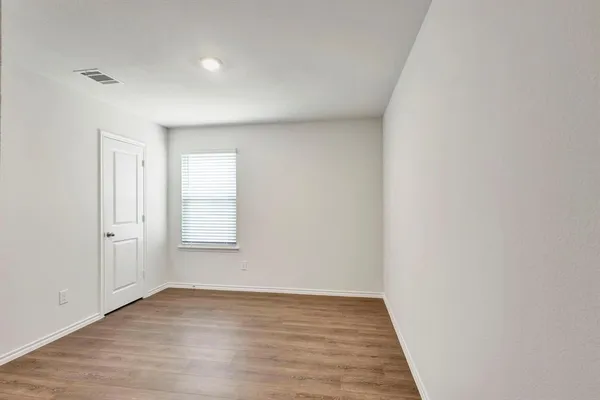 a view of an empty room and wooden floor