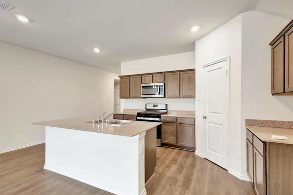a kitchen with stainless steel appliances granite countertop a sink stove and refrigerator